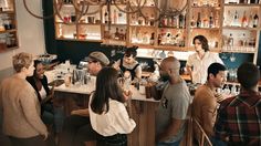 a group of people standing around a bar