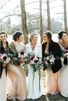 a group of women standing next to each other holding bouquets in their hands and smiling