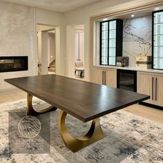 a large wooden table sitting on top of a rug in front of a fire place