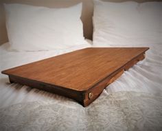 a wooden tray sitting on top of a bed