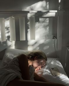 a woman laying in bed with her head on the pillow