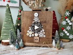 a christmas tree made out of buttons on a wooden board