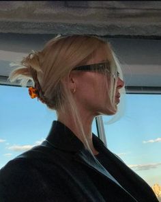 a woman with blonde hair and sunglasses looking out the window