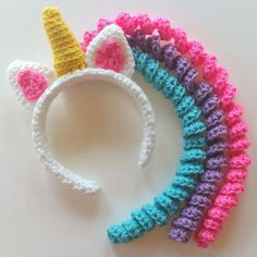 several crocheted unicorn headbands on a white surface