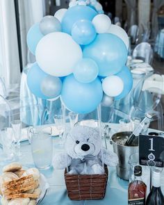 a bunch of blue and white balloons sitting on top of a table next to food