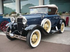 an antique car parked in front of a building