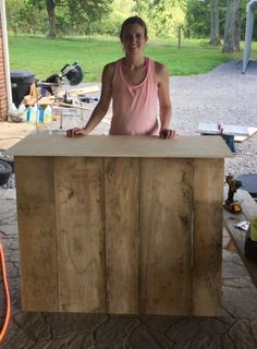 a woman standing behind a counter made out of wood