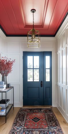 a blue front door with a red ceiling and rug on the floor next to it