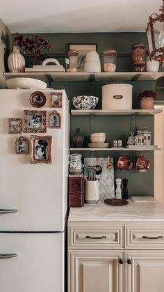 a white refrigerator freezer sitting inside of a kitchen next to a wall filled with pots and pans