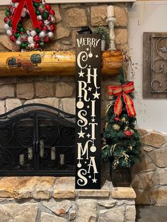 a merry christmas sign sitting in front of a fireplace