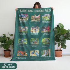 a woman holding up a green poster with pictures of native birds and national parks on it