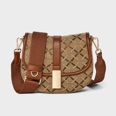 This Jacquard Saddle Crossbody Bag from A New Day™ in brown showcases a structured silhouette with a geometric pattern for an attractive, chic look. It features a roomy main compartment and an interior zip pocket for easy organization of your belongings, as well as an overlapping flap with a gold-tone buckle accent and magnetic closure. Plus, the detachable adjustable shoulder strap makes carrying a breeze whether you sling it over one shoulder or carry it in hand. A New Day™: Style that goes wh Target Purse, Saddle Crossbody Bag, Bucket Handbags, Straw Bags, Easy Organization, Crossbody Messenger Bag, Mini Handbags, A New Day, Magnetic Closure