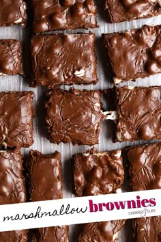 chocolate brownies are lined up on a sheet of parchment paper and ready to be eaten