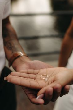 a man and woman holding each other's hand with their wedding rings on them