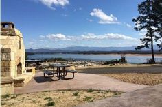 there is a picnic table next to the lake