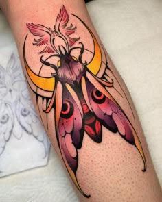 a colorful tattoo design on the leg of a woman's leg with a moth and moon