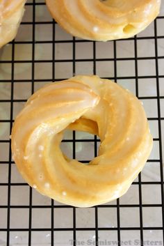 three glazed donuts sitting on top of a cooling rack