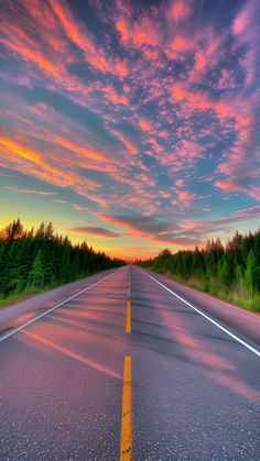 the sun is setting on an empty road with trees in the background