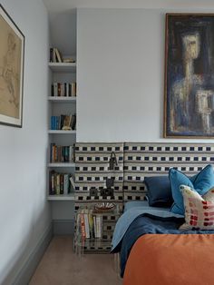 a bed sitting in a bedroom next to a book shelf