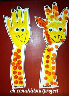 two paper giraffes with orange dots on them