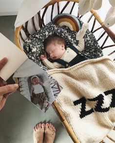 a baby is laying in a chair and holding a book