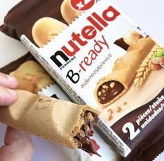 someone is holding up a nutella bar to show it's wrapper side