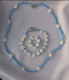 a blue beaded necklace with yellow and white flowers