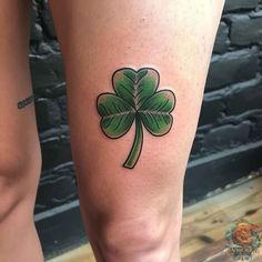 a woman's leg with a shamrock tattoo on it