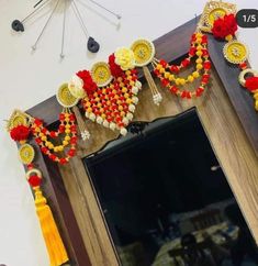 a mirror decorated with red, yellow and white decorations