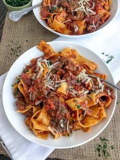 two white bowls filled with pasta and meat