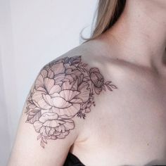 a woman with a flower tattoo on her shoulder