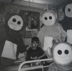 an old black and white photo of children in bed with five stuffed animals around them