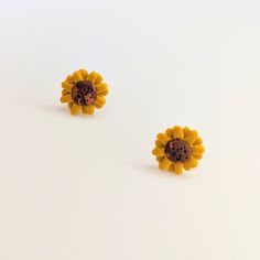 Cute sunflower stud earrings. All orders are packaged with care. Each box includes tissue paper, a tealight and a KelZo postcard. Product details: Polymer clay Approx 1cm Hypoallergenic surgical steel studs ****Colours may vary slightly from image due to resolution differences. Colour patterns may not match photographed item but will be cut from same piece/collection. Shapes and sizes may also vary due to the nature of handmade products.*** Care and Returns Please handle your KelZo Jewellery with care, as it is handmade and more fragile compared to mass market jewellery. Returns/replacements on pierced items are not accepted unless faulty, due to hygiene reasons. Please read our care guide and returns policy for more detailed information. Postage Please note, we aim to post all parcels wit Yellow Sunflower Design Earrings As Gift, Yellow Sunflower Design Flower Earrings As Gift, Cute Sunflower, Mass Market, Tealight, Handmade Products, Tissue Paper, Color Patterns, Tea Lights