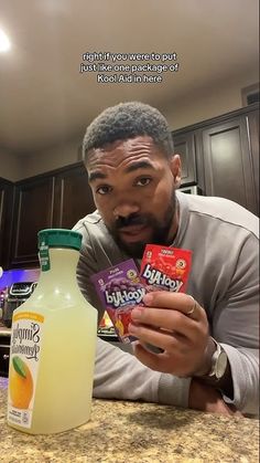 a man is holding some kind of milk and orange juice in front of his face