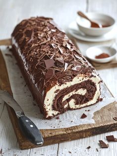 there is a chocolate roll on the cutting board