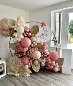 balloons are arranged in the shape of flowers and leaves for a balloon wall display at a party