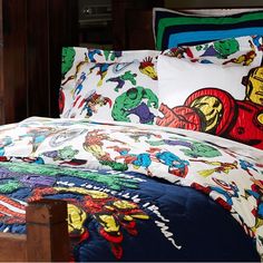 the bed is made up with comic characters on it