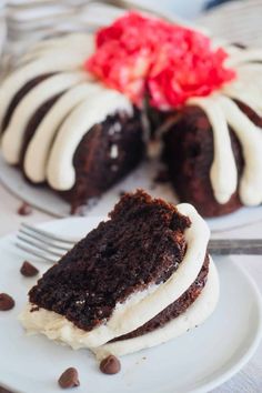 a slice of chocolate cake with white frosting on a plate