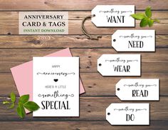 wedding card and tags for the bride or groom on wood background with greenery leaves