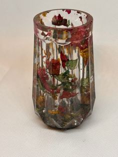 a glass vase filled with flowers on top of a table