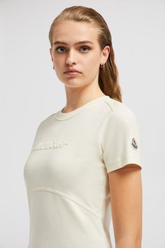 An elevated essential, this short sleeve t-shirt is embellished with a delicate beaded logo. The top is featured in a crew neck silhouette, crafted from the softest cotton jersey. Embroidered Logo Tops For Summer, White Cap Sleeve T-shirt, Fitted Crew Neck Top With Embroidered Logo, Shaun White, Personalized Jacket, Cardigan Shirt, Outerwear Outfit, Ski Pants, Shell Jacket