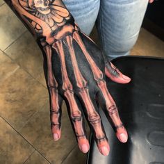 a person's hand with a skeleton tattoo on it