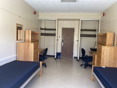 an empty room with several beds and desks