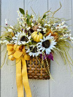 a basket filled with lots of flowers on top of a wall