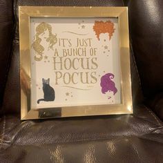 a gold frame with a black cat on it that says, it's just a bunch of hocks pocuss