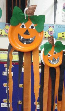 three pumpkins with green leaves on them are hanging from the back of a classroom door