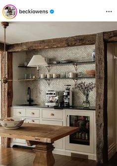 a kitchen with white cabinets and wooden shelves