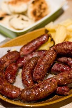 two plates with sausages and chips on them