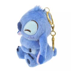 a blue stuffed animal hanging from a gold key chain