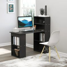 a desk with a computer on it in front of a window and a white chair